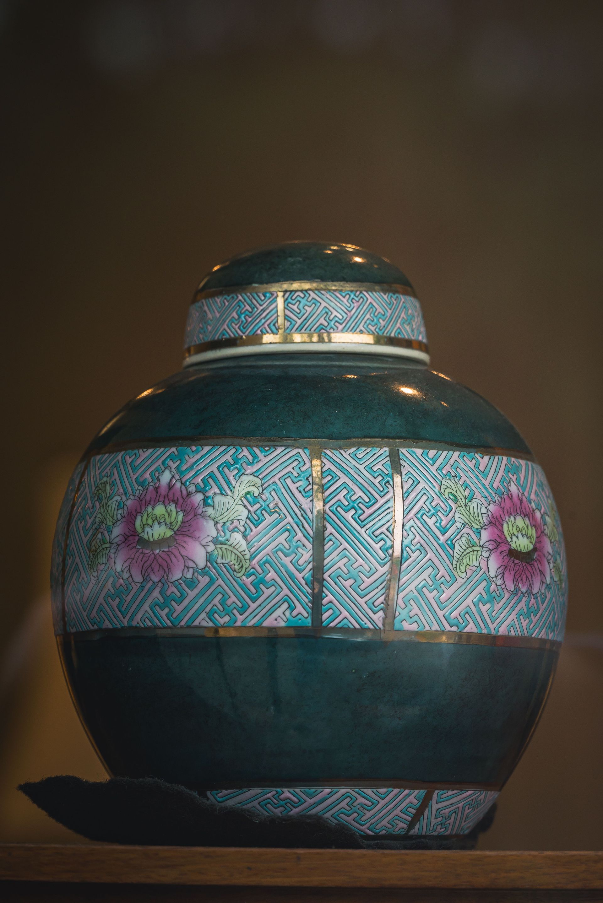 Close-up of a blue hand-painted ceramic urn with floral patterns.